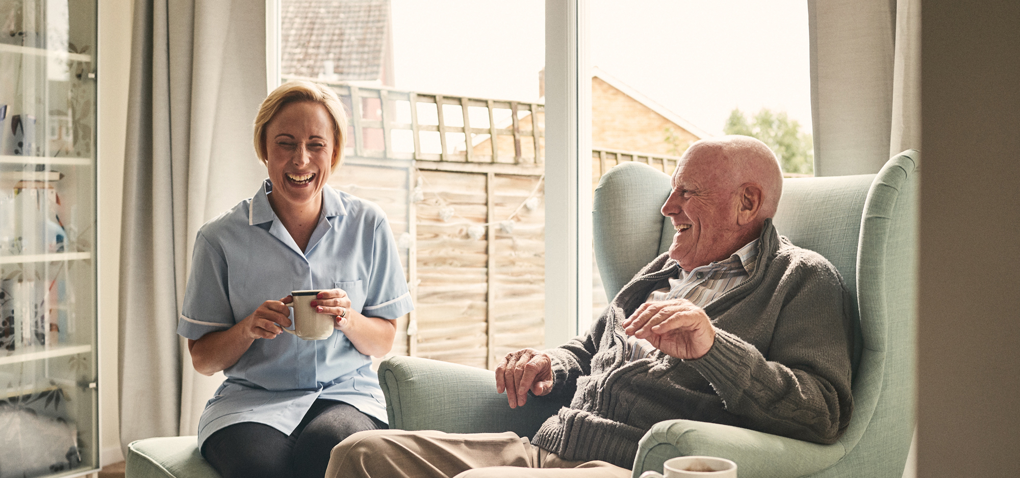 Nurse and patient sharing a having a cup of coffee